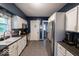 Galley kitchen with stainless steel appliances, contrasting countertops, stylish backsplash and a tiled floor at 3934 N Kenwood Ave, Indianapolis, IN 46208