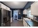 Open kitchen area featuring stainless steel refrigerator, tiled flooring and easy access to the dining room at 3934 N Kenwood Ave, Indianapolis, IN 46208