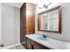 Bathroom features wooden cabinetry and large mirror over a blue sink, providing ample storage at 415 Woodhill Dr, Indianapolis, IN 46227