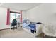 Cozy bedroom featuring a daybed, white walls, bright lighting, and view of the yard through the window at 415 Woodhill Dr, Indianapolis, IN 46227