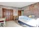 Bedroom with light stone wall pattern, closet space, and an open doorway, plus a bed and study area at 415 Woodhill Dr, Indianapolis, IN 46227