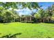 Spacious single-story home featuring a lush green lawn and mature trees at 415 Woodhill Dr, Indianapolis, IN 46227