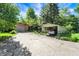 A detached garage and car port on a long cracked driveway at 415 Woodhill Dr, Indianapolis, IN 46227