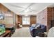 Living room boasts wood paneling, brick accent wall, modern ceiling fan, and comfortable seating at 415 Woodhill Dr, Indianapolis, IN 46227