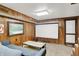 Living room features wood paneling, a cozy couch, and projector screen for immersive entertainment at 415 Woodhill Dr, Indianapolis, IN 46227