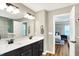 Bright bathroom featuring a double sink vanity with dark cabinets and quartz countertops, alongside wood-look flooring at 4602 Hayward Way, Westfield, IN 46062