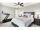 Bedroom featuring a treadmill, ceiling fan, and a comfortable bed with decorative pillows and wood nightstands at 4602 Hayward Way, Westfield, IN 46062
