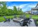 Inviting outdoor space features a stone fire pit, surrounded by Adirondack chairs and lush greenery at 4602 Hayward Way, Westfield, IN 46062