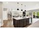 Open-concept kitchen featuring an island with sink, modern appliances and seamless flow to the living room and outdoor patio at 4602 Hayward Way, Westfield, IN 46062