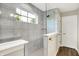 Walk-in shower featuring light gray tile walls, a glass enclosure, a window, and a white accent wall at 4602 Hayward Way, Westfield, IN 46062