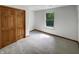 Bedroom features carpet, a window, and a closet with wood sliding doors at 4825 May Ridge Ln, Indianapolis, IN 46254