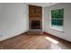 Bright room features wood-look flooring, brick fireplace and a window with nature views at 4825 May Ridge Ln, Indianapolis, IN 46254