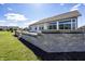 A serene backyard features a concrete patio, brick retaining wall, and plenty of green grass at 5196 Canberra Ct, McCordsville, IN 46055