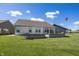 Well-maintained home backyard featuring a concrete patio, brick retaining wall, and a lush green lawn at 5196 Canberra Ct, McCordsville, IN 46055
