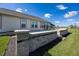 The backyard showcases a concrete patio with brick retaining wall, a lush lawn, and a picturesque landscape at 5196 Canberra Ct, McCordsville, IN 46055