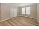 Bright bedroom featuring wood-look flooring, crown molding, and ample natural light from two windows at 5196 Canberra Ct, McCordsville, IN 46055