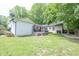 The backyard has a furnished deck, green grass, and mature trees creating a serene outdoor living space at 5601 Rosslyn Ave, Indianapolis, IN 46220