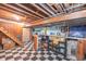 The basement features a vintage-style bar area, stairs, and checkered flooring, creating a retro-inspired recreational space at 5601 Rosslyn Ave, Indianapolis, IN 46220