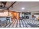 The basement offers a finished area with a classic checkered floor, a bar, and a cozy fireplace for versatile use at 5601 Rosslyn Ave, Indianapolis, IN 46220