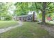 Charming brick home with mature trees and a stone walkway leading to the front door at 5601 Rosslyn Ave, Indianapolis, IN 46220