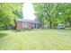Beautiful brick home with landscaped front yard and mature trees at 5601 Rosslyn Ave, Indianapolis, IN 46220