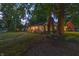 Beautiful brick house featuring mature trees, manicured lawn and an American flag at 5601 Rosslyn Ave, Indianapolis, IN 46220