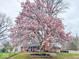 The brick home has a beautiful blooming tree in the front yard creating stunning curb appeal at 5601 Rosslyn Ave, Indianapolis, IN 46220