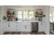 Bright kitchen with white cabinetry, stainless steel dishwasher, and farmhouse style sink at 5601 Rosslyn Ave, Indianapolis, IN 46220