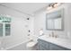 Bathroom featuring a shower-tub combo with white subway tile and vanity with white marble countertop at 6020 Gladden Dr, Indianapolis, IN 46220