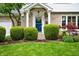 Inviting front entrance with a vibrant blue door, decorative wreath, and meticulously maintained landscaping at 6020 Gladden Dr, Indianapolis, IN 46220