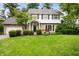 Charming two-story home with a well-manicured lawn and landscaped yard featuring mature trees and manicured shrubbery at 6020 Gladden Dr, Indianapolis, IN 46220