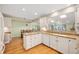 Well-lit kitchen features white cabinetry, granite countertops, and hardwood floors with barstools at 6020 Gladden Dr, Indianapolis, IN 46220