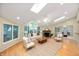 Bright living room featuring a vaulted ceiling, skylights, fireplace and large windows at 6020 Gladden Dr, Indianapolis, IN 46220