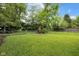 Spacious backyard with green grass, mature trees, and brick fire pit at 6045 Dewey Ave, Indianapolis, IN 46219