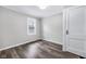 Neutral bedroom featuring wood-look floors, white trim, and a window with natural light at 6045 Dewey Ave, Indianapolis, IN 46219
