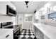 Bright kitchen features checkered floors, modern stainless steel appliances, and a view to another room at 6045 Dewey Ave, Indianapolis, IN 46219