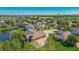 Aerial view of neighborhood featuring a large house with a pond, lush trees, and green lawns at 7093 Republic Ln, Indianapolis, IN 46259