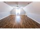 Finished attic with wood floors and window with white sheer curtains at 7093 Republic Ln, Indianapolis, IN 46259