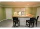 Basement bar with seating, light wood countertop, cabinetry and a small refrigerator at 7093 Republic Ln, Indianapolis, IN 46259