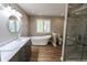 Primary bathroom featuring a soaking tub, vanity sink, and walk-in shower with marble tiles at 7093 Republic Ln, Indianapolis, IN 46259