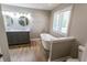 Modern bathroom featuring a soaking tub, double vanity, wood-look flooring, and shuttered window at 7093 Republic Ln, Indianapolis, IN 46259
