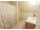 Cozy bathroom with a floral shower curtain, single sink vanity, and neutral tile flooring at 7093 Republic Ln, Indianapolis, IN 46259