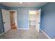 Bedroom with blue walls with entry into a bedroom and an open closet with rod and shelving at 7093 Republic Ln, Indianapolis, IN 46259