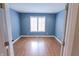 Cozy bedroom with laminate floors, natural light from window, and neutral blue wall color at 7093 Republic Ln, Indianapolis, IN 46259