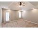 Spacious bedroom with a tray ceiling, ceiling fan, carpet, and a door to the outside at 7093 Republic Ln, Indianapolis, IN 46259