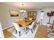 Open dining room with wood table, chandelier, and a view of the stairwell and kitchen at 7093 Republic Ln, Indianapolis, IN 46259