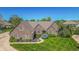 Aerial view of brick home with landscaping, green lawn, and a winding driveway at 7093 Republic Ln, Indianapolis, IN 46259