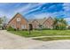 Charming brick home showcasing a lush lawn and mature landscaping at 7093 Republic Ln, Indianapolis, IN 46259