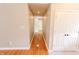 Hallway with wooden floors that leads to another room and a white door on the right at 7093 Republic Ln, Indianapolis, IN 46259