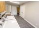 Practical laundry area with side-by-side machines, utility sink and view to a bathroom at 7093 Republic Ln, Indianapolis, IN 46259